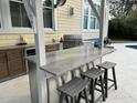 This outdoor kitchen offers a prep island, bar seating, stainless steel appliances and a built-in grill at 1535 Watoga Way Way, Mount Pleasant, SC 29466