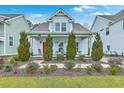 Beautiful two-story home with a meticulously landscaped front yard, a vibrant red door, and light blue window shutters at 1702 Sparkleberry Ln, Johns Island, SC 29455