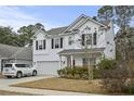 Charming two-story home features a bright red front door and a two-car garage at 2025 Lanneau Ln, Johns Island, SC 29455
