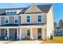 Charming two-story townhome exterior with front porch, neutral siding, black door, and well-manicured landscaping at 207 Abercom Place Dr, Moncks Corner, SC 29461