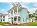 Side view of charming two-story home with a covered porch and balcony, featuring a light blue exterior and white trim at 2181 Blue Bayou Blvd, Johns Island, SC 29455