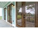 Close up view of the light streaming through the dark trimmed glass doors leading to a covered patio at 2181 Blue Bayou Blvd, Johns Island, SC 29455