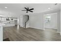 Open-concept living room featuring a ceiling fan and access to the kitchen and staircase at 2205 Blue Bayou Blvd, Johns Island, SC 29455