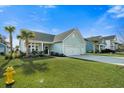 Lovely single Gathering home with a covered porch, neat landscaping, and an attached two-car garage at 2379 Lenwick Hall Ln, Johns Island, SC 29455