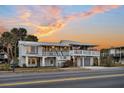 Charming two-story beach house with a metal roof, double porches, and a ground-level garage at 407 Palmetto Blvd, Edisto Beach, SC 29438