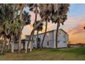 View of the side of the beach house through the palm trees at 407 Palmetto Blvd, Edisto Beach, SC 29438