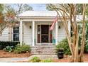 Close up of inviting front porch with brick steps, stately columns, and charming wood door at 521 London Bridge Rd, Mount Pleasant, SC 29464