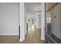 Inviting entryway with light wood flooring, white walls, and view to chandelier and rear windows at 7806 Park Gate Dr, North Charleston, SC 29418