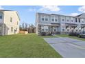Attractive townhome showcasing light gray siding, stone accents, and a spacious front lawn at 7806 Park Gate Dr, North Charleston, SC 29418