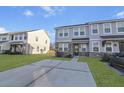 Beautiful townhome featuring stone accents, light gray siding, and a spacious concrete driveway at 7806 Park Gate Dr, North Charleston, SC 29418