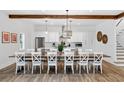 Bright dining room features a wooden table with seating for twelve and a view into the modern kitchen at 112 E Huron Ave # C, Folly Beach, SC 29439