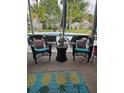 Screened porch with wicker seating, colorful pillows, and a tropical pineapple rug overlooking the backyard at 1915 Sweetfern Rd, Hanahan, SC 29410