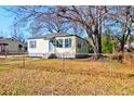 Charming single-story home with blue door, grey shutters, and chain link fence at 2694 Olympia Ave, North Charleston, SC 29405