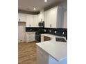 Modern kitchen features white cabinets, stainless steel appliances and black backsplash at 3004 Harvey Ave, North Charleston, SC 29405