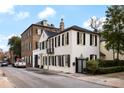 Street view of a charming white house with black shutters, complemented by surrounding buildings at 35 Tradd St, Charleston, SC 29401