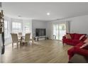 Open-concept living room with hardwood floors and large windows, seamlessly connecting to the outdoors at 4875 Carnoustie Ct, Summerville, SC 29485