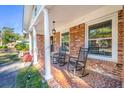 Inviting front porch with rocking chairs and brick flooring, perfect for relaxing at 6024 Meadowcliff Ave, Hanahan, SC 29410