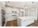 A spacious white kitchen features stainless steel appliances, a subway tile backsplash, and an island with pendant lighting at 714 Breakers Reef Ln, Huger, SC 29450