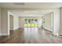 Bright living room with wood floors and sliding glass doors to the backyard with view of grassy lawn and neighbor's house at 714 Breakers Reef Ln, Huger, SC 29450