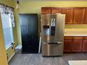 Kitchen featuring stainless steel refrigerator, wood cabinets, and tile flooring near bright window at 7364 Suncatcher Dr, Hanahan, SC 29410