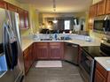 Bright kitchen with stainless steel appliances, wood cabinets, and an open view to the living area at 7364 Suncatcher Dr, Hanahan, SC 29410