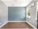 A bright, simply furnished room with a blue accent wall, hardwood floors, a window, and white trim at 7857 Montview Rd, North Charleston, SC 29418