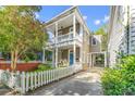 Inviting two-story home with a white picket fence and a lush front yard at 80 Smith St, Charleston, SC 29401