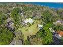 Aerial view of a home with mature trees and large grassy front yard near the coast and with neighboring houses nearby at 901 Morton Waring Ln, Pinopolis, SC 29469