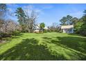 Charming home with large front yard, lush landscaping, and a guest house with a matching green metal roof at 901 Morton Waring Ln, Pinopolis, SC 29469