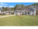 Exterior view of single story home featuring attached two-car garage and large front yard at 106 Ranworth Ln, Summerville, SC 29485