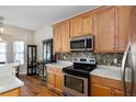 Well-lit kitchen with stainless steel appliances, mosaic backsplash, and wood cabinets at 109 Presidio Bnd, Summerville, SC 29483