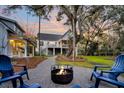 Inviting backyard with a cozy fire pit surrounded by Adirondack chairs and a picturesque view of the home at 129 Sparrow Dr, Isle of Palms, SC 29451