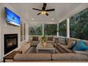 Relaxing screened porch with comfortable seating, a fireplace, and a TV, perfect for enjoying the outdoors at 129 Sparrow Dr, Isle of Palms, SC 29451