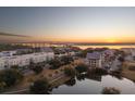 Picturesque sunset aerial view of waterfront homes and marshland; expansive bridge in the background at 145 Pier View St # 403, Charleston, SC 29492