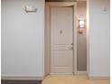 Close up of a neutral colored apartment entry door with a peephole and a unit number sign at 145 Pier View St # 403, Charleston, SC 29492