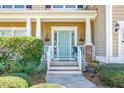 Welcoming front porch with blue door, white railings and meticulously maintained landscaping at 188 Donning Dr, Summerville, SC 29483