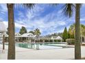 Community pool with cabanas surrounded by lush palm trees and blue skies at 188 Donning Dr, Summerville, SC 29483