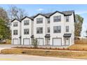 Three-story townhouses feature white siding, a garage, and are landscaped with new foliage at 2191 Helm Ave, North Charleston, SC 29405