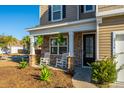 Inviting front porch with rocking chairs and stone-accented columns at 2734 Sunrose Ln, Johns Island, SC 29455