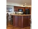 Open kitchen area with wooden cabinets, countertops, a microwave, and a black refrigerator at 280 Driftwood Ln, Edisto Beach, SC 29438