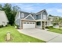 Charming two-story home featuring a stone facade, blue siding, and a spacious driveway at 331 Weston Hall Dr, Summerville, SC 29483