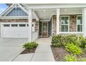 Inviting front porch with stone accents, white columns, and well-maintained landscaping at 331 Weston Hall Dr, Summerville, SC 29483