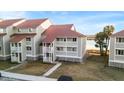 Attractive condo exterior with red metal roof, white trim, and balcony offering views of the surrounding area at 46 Mariners Cay Dr, Folly Beach, SC 29439