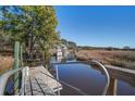 This home has a dock and allows access to deep water, with marsh views at 7527 Ladys Secret Ln, Awendaw, SC 29429