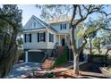 Two-story home features a welcoming front porch with mature landscaping and garage at 8587 Middleton Point Ln, Edisto Island, SC 29438