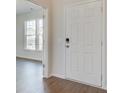 Bright entryway featuring wood-look floors and white painted six-panel door at 1012 Swamp Rose Run, Summerville, SC 29485