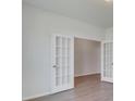 Neutral room featuring an opening with white french doors and wood-look floors at 1012 Swamp Rose Run, Summerville, SC 29485