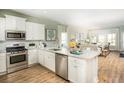 Modern kitchen with granite countertops, stainless steel appliances, white cabinetry and an open layout to the living area at 1016 Swamp Rose Run, Summerville, SC 29485