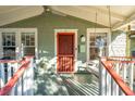 Cozy front porch with swing, ceiling fan, and bright red door for relaxing outdoors at 12 Poplar St, Charleston, SC 29403