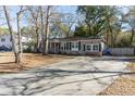 Home's driveway and landscaping with mature trees on a sunny day at 1239 Wappetaw Pl, Mount Pleasant, SC 29464
